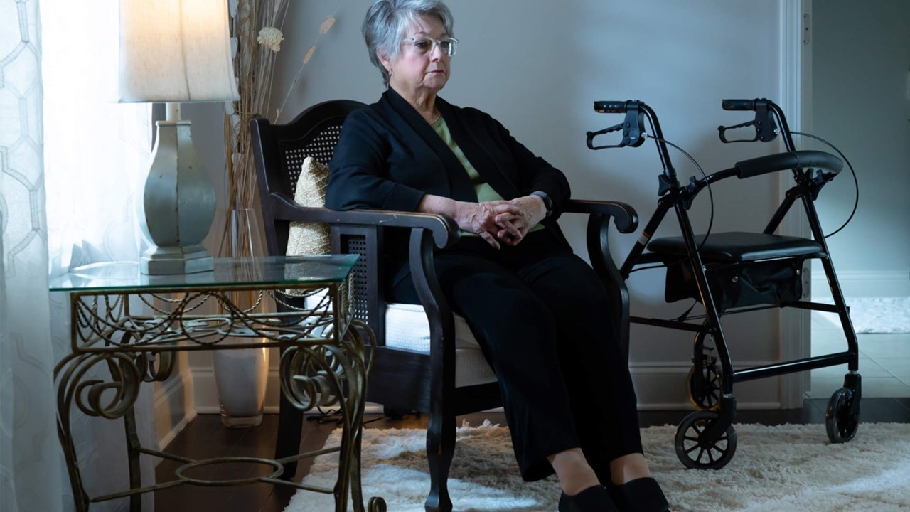 gloomy patient sitting isolated at home next to her walker