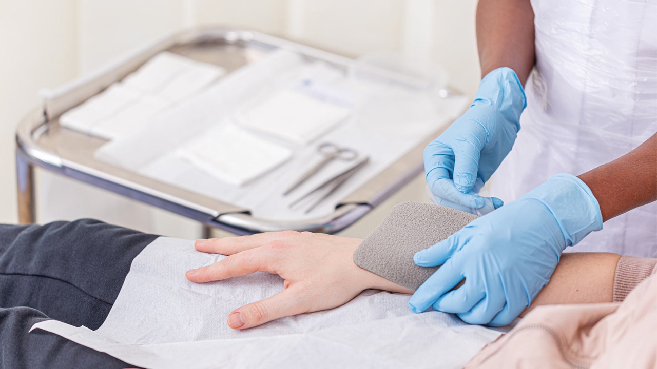 Nurse putting on a dressing on patient arm