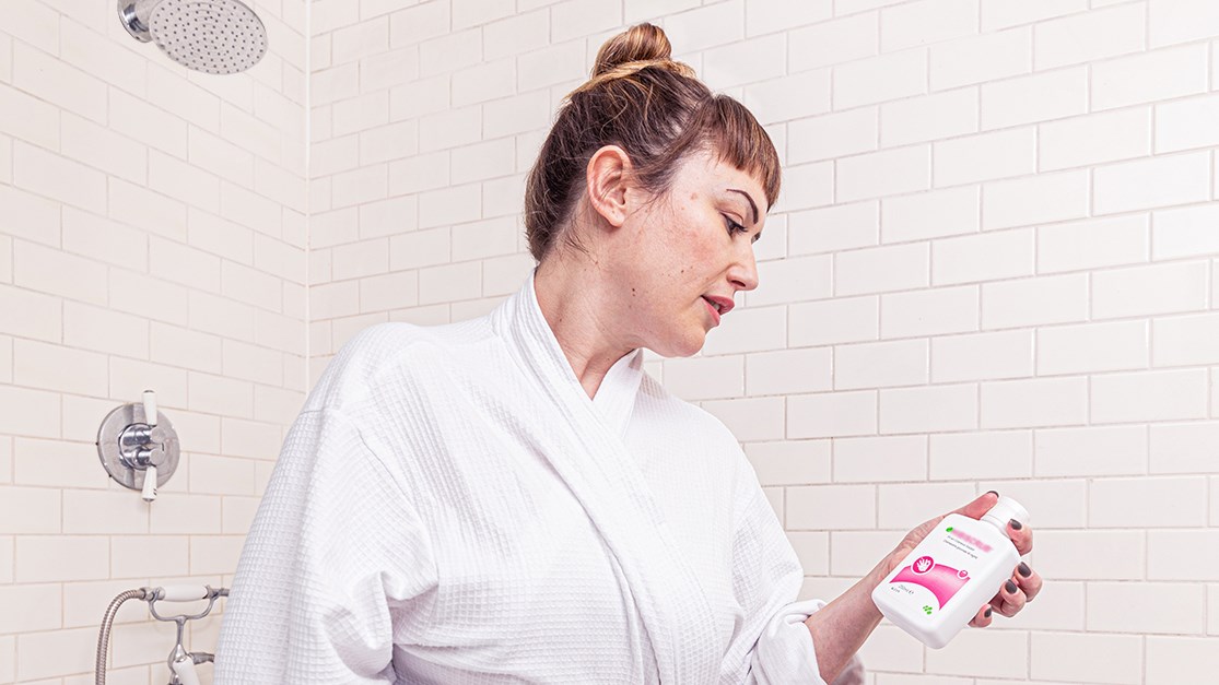 Vrouw in de badkamer met Hibiscrub in de hand