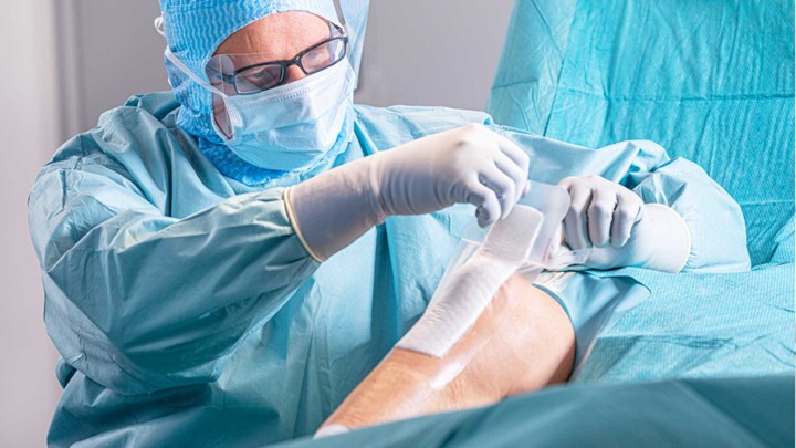 Surgeon applying dressing post-op