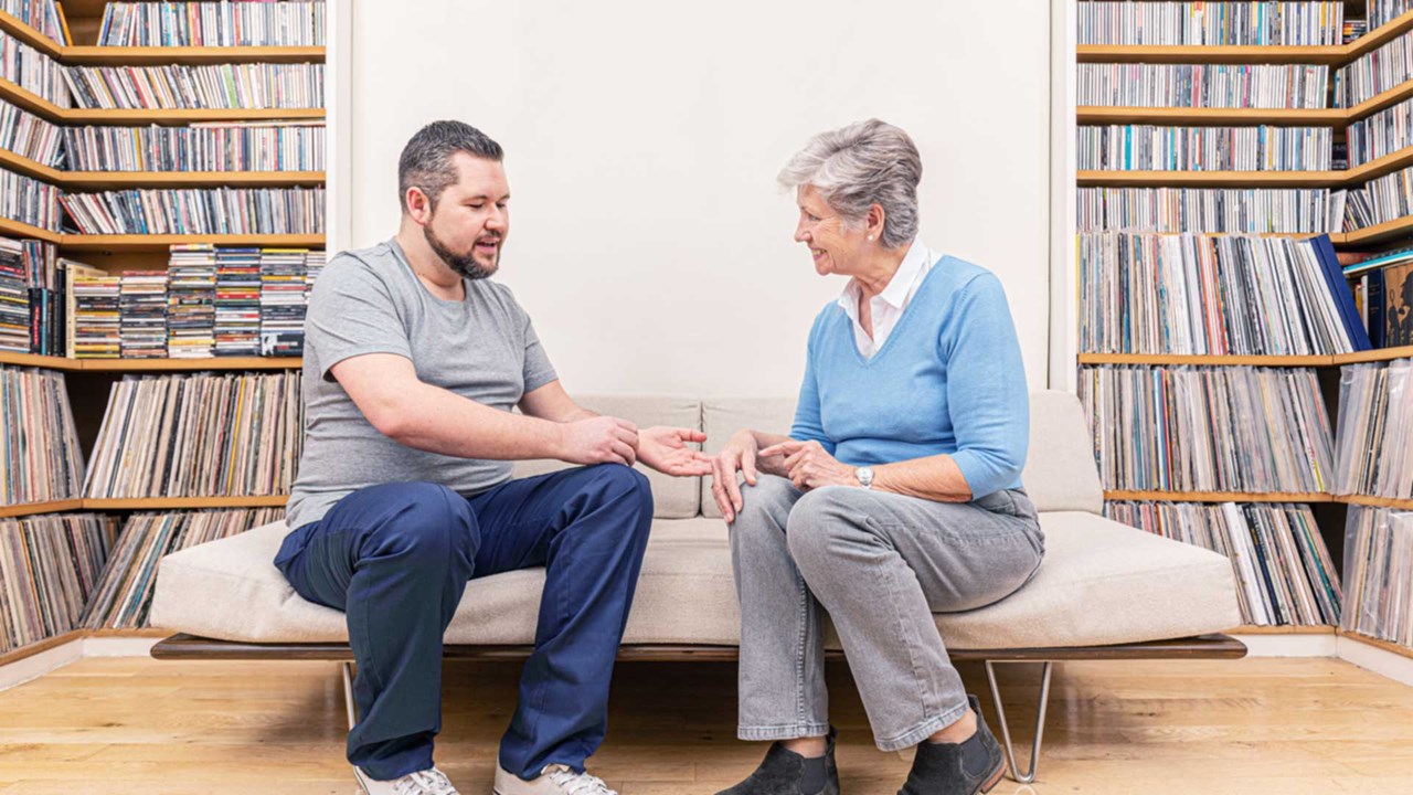 Profesional sanitario observando la mano de una señora de edad avanzada