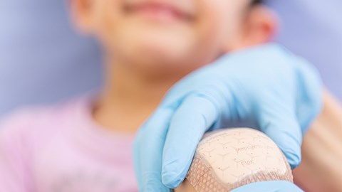 Aanbrengen van verband op knie van patiënt